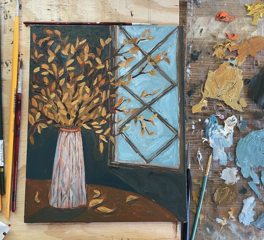 Oil painting of a vase of fall leaves in front of a window.